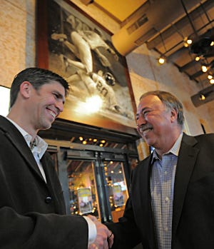 Restaurateur Jerry Remy, right, meets artist Brian Fox for the very first time beneath the enormous action picture Fox painted of the former Red Sox player at the VIP party at Jerry Remy's Sports Bar and Grill on Thursday.