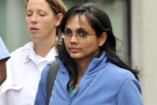 FILE - In a Wednesday, Oct. 10, 2012 file photo, Annie Dookhan leaves a Boston courthouse escorted by court officers. Dookhan, a Massachusetts chemist accused of deliberately faking test results on drug samples in criminal cases, was indicted Monday, Dec. 17, 2012 on 27 charges, including obstruction of justice, tampering with evidence, perjury and pretending to hold a college degree. Dookhan's alleged misconduct led state police to shut down a state lab used by police departments to test drugs in criminal cases.