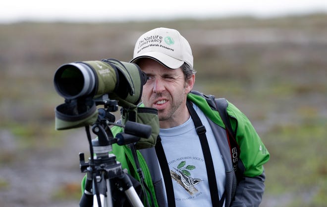 Rich Kostecke, an associate director at the Nature Conservancy in Texas, 
looks through his spotting scope last week during the annual count of birds 
along the Texas Gulf Coast.ASSOCIATED PRESS PHOTOS / DAVID J. PHILLIP