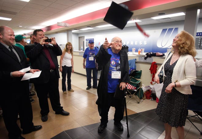 Wearing his graduation gown, World War II veteran George Hashman flings his mortarboard in the air after becoming Springfield High School's newest graduate, 70 years after he left school early in 1942 to join the service. A diploma presentation by Springfield school board president William Looby took place at Capital Airport after Hashman returned from spending the day with other veterans in Washington, D.C. as part of the 14th Land of Lincoln Honor Flight on Tuesday, April 17, 2012. From left to right: Looby, school board member Scott McFarland, Hashman, and school board vice president Susan White.