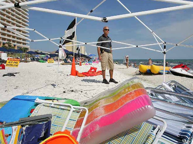 Panama City Beach Code Enforcement Officer James Tindle checks out an abandoned beach tent in summer 2011, before the “leave no trace” ordinance. At the time, Tindle said the tents had become so inexpensive that some parts of the beach look like a “metal recycling yard” because of the aluminum tent polls left behind.