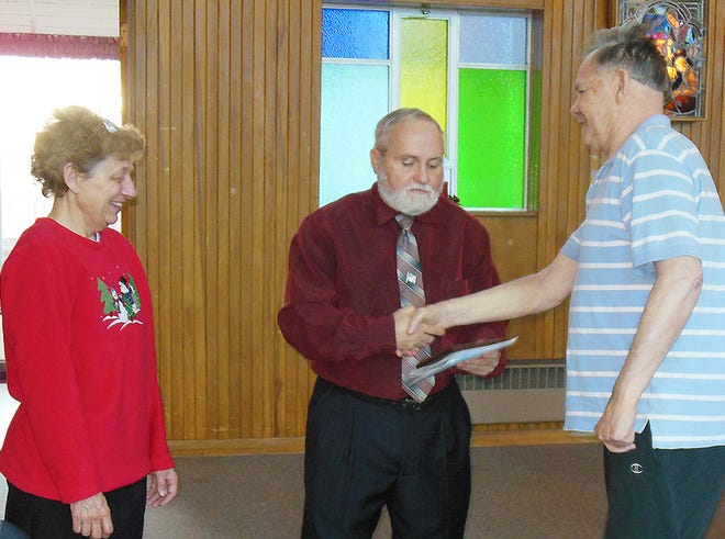 From left, Laura Hailston and Ron Schoonmaker present a plaque and Christmas cards to David Schultz, a veteran who resides at Folts Homes in Herkimer.