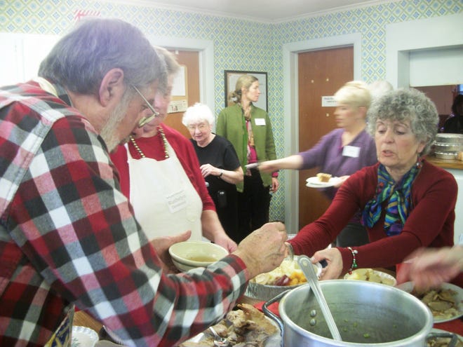 Volunteers Rena Lukoski, right, and her husband, Luke, of Hanover, fill  a take-home container with turkey and other fixings during the 13th annual Christmas dinner at the Church Hill United Methodist Church in Norwell.