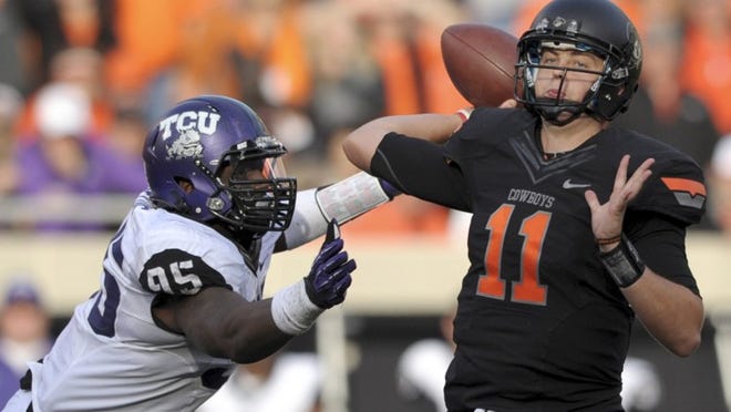 TCU defensive end Devonte Fields, left, pressuring Oklahoma State quarterback Wes Lunt, made the freshmen All-American team. In fact, he’s one of 35 freshmen to play for the Horned Frogs, who face Michigan State on Saturday night in the Buffalo Wild Wings Bowl.