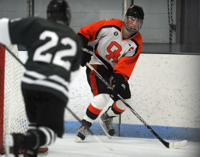 Oliver Ames High School's Justin Davidner faces a Mansfield High School defender during the varsity hockey game in Brockton on Wednesday, December 26, 2012.