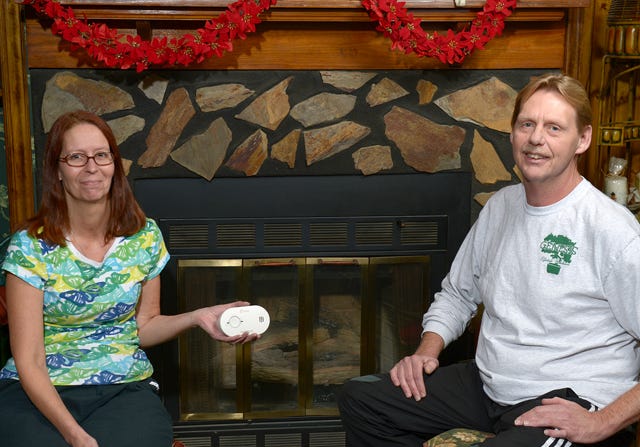 Alan and Cynthia Stevens sit in front of their fireplace on Thursday night. Photo by Sam Roberts / Times-News.