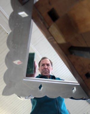 Dick Orr is a third generation cabinet maker who now plies his trade at the old Tree and Park barn in Hingham Centre. Here he is sanding the primer off of a mirror frame that he built. Robin Chan photo 2012