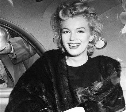 In this June 2, unknown year, file photo, actress Marilyn Monroe smiles in a car after arriving tousled from an all-night plane flight from Hollywood to Idlewild Airport, in New York. The actress said she planned to rest in New York before going to England to make a new movie with Sir Laurence Olivier. In late 2012, the FBI has released a new version of files it kept on Monroe that reveal the names of some of her acquaintances who had drawn concern from government officials and members of her entourage over their suspected ties to communism.