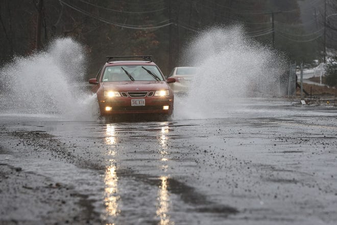 A car drives through some roadway flooding on Grove Street in Franklin after a storm hit the area on Thursday.