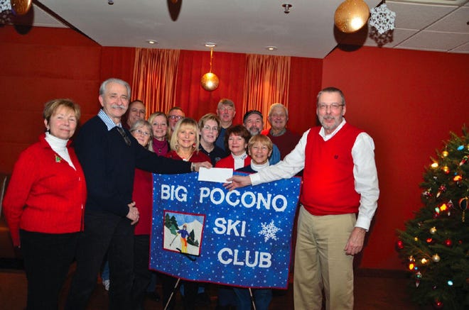 Big Pocono Ski Club President William Wenton, right, presents Bill Raczko, president of Support Services for Seniors, with a $600 donation. Standing behind the banner are board members of Big Pocono Ski Club.