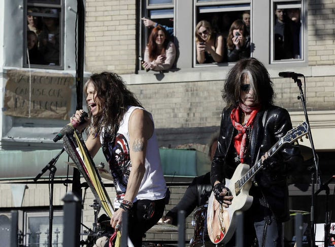 Aerosmith’s Steven Tyler, left, and Joe Perry, performing a free concert last month in Boston’s Allston neighborhood as fans watch from the apartment building which was the band’s home in the early 1970s.