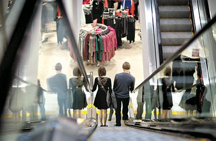 In this Wednesday, Dec. 12, 2012, photo, a couple descend an escalator while shopping at an H& M store, in Atlanta. U.S. consumer confidence tumbled in December, driven lower by fears of sharp tax increases and government spending cuts set to take effect next week. The Conference Board said Thursday that its consumer confidence index fell this month to 65.1, down from 71.5 in November. That's second straight decline and the lowest level since August. (AP Photo/David Goldman)