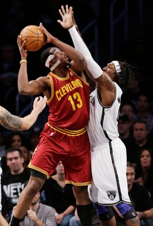 Cleveland Cavaliers' Tristan Thompson (13) shoots over Brooklyn Nets defender Gerald Wallace during the first half of Saturday's game in Brooklyn.