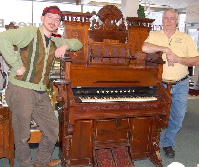 John Walker (left) and his father, Tim, stand next to an organ being donated to the Grosvenor House. NANCY HASTINGS PHOTO