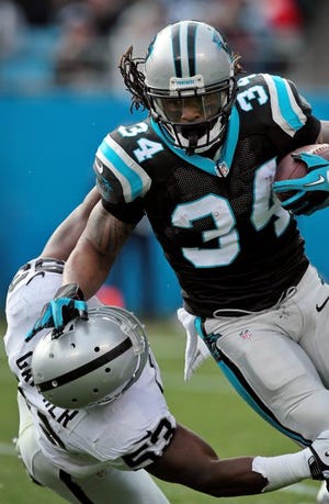Panthers running back DeAngelo Williams tries to break a tackle during the Dec. 23 game against Oakland.