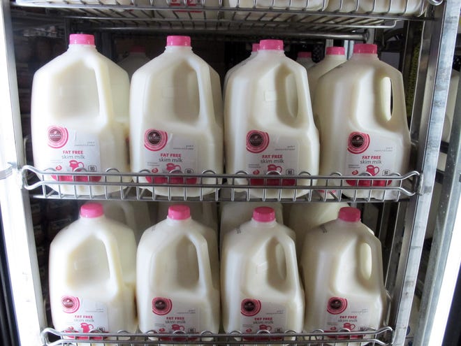 Gallons of milk are arranged at a Milwaukee grocery store on Tuesday, Dec. 4, 2012. (AP Photo/Dinesh Ramde)