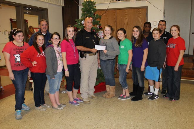 Pictured from left to right are Beta Club students Tayler Hooper, Braylee Mayers, Reace Dedon, Emily Martinez, Major Lee Anderson of the Ascension Parish Sheriff’s Office, Miranda Brown, Brooke Plauche, Mikayla Timmons, Landeon Lieux, Stephanie St. Pierre(Sponsor). Back row: SSrgt. Joey Meyers, DJ Ferguson, and Jay Benoit (Principal). The Beta Club of Lake Elementary presents a $5,000 check to the Ascension Parish Sheriff’s Office Christmas Crusade program.