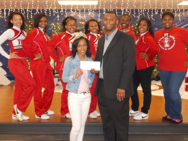 DHS’s 2012 Homecoming Queen, Kenya Madison, is presented with a check from principal Dr. Esrom Pitre before going to the AutoZone Liberty Bowl on Dec. 31.