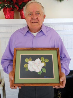 Frazier Bruton of Kinston holds his painting, ‘A White Rose.’ Bruton was named December December Artist of the Month by the Lenoir County Council on Aging.
