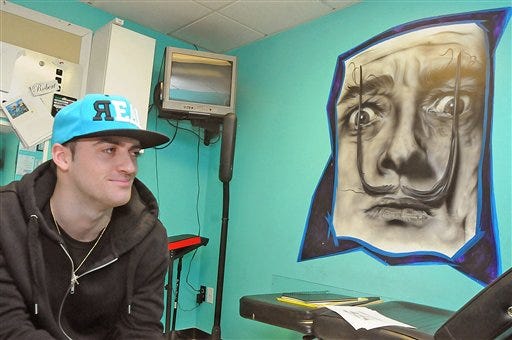 In this Dec. 20, 2012 photo, tattoo artist Ryan Jones poses in his office at Action Ink in Taunton, Mass. The tattoo artist is beginning to make a big name for himself, having already attracted some high profile clientele.