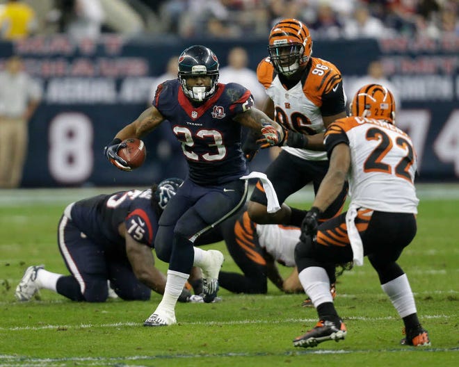 Houston Texans running back Arian Foster carroes the ball in front of Cincinnati Bengals strong safety Nate Clements Saturday during the third quarter.