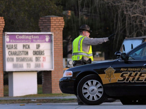 A New Hanover County deputy directs traffic at Codington Elementary School on Carolina Beach Road on Monday morning.