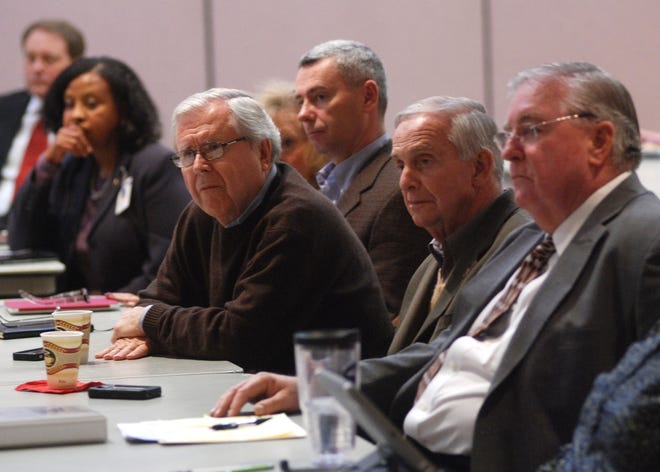 Bill Naumann, former CEO of Hatteras Yachts, leans forward on a table to listen during a presentation of lobbying efforts to protect Cherry Point, Next to Naumann at right are Sonny Roberts, of Impact Communications, and Havelock Commissioner Danny Walsh.