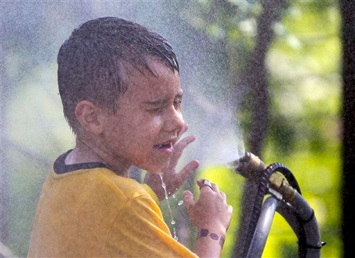 Alexander Merrill , 6, of Sioux Falls, S.D., cools off in July at the Henry Doorly Zoo in Omaha, Neb., as temperatures reached triple digits. Federal meteorologists say America was deep fried in 2012, becoming the hottest year on record by far.
