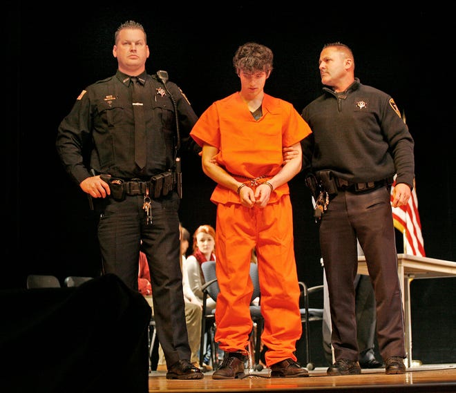 Nick McNeil, a North Quincy High senior, is flanked by Deputy Sheriffs Tim Flynn and John O’Brien during the mock trial held on Tuesday, Jan. 8, 2013, at Quincy High School.