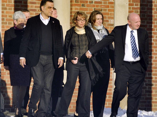 Former U.S. Rep. Gabrielle Giffords, center, holds hands with her husband, Mark Kelly, while exiting Town Hall at Fairfield Hills Campus in Newtown, Conn. after meeting with Newtown First Selectman Pat Llodra and other officials on Friday, Jan. 4, 2013. At far left is Lt. Gov. Nancy Wyman; behind Giffords to the left is U.S. Sen. Richard Blumenthal. Giffords also met with families of the victims of the Sandy Hook Elementary massacre that left 26 people dead. (AP Photo/The News-Times, Jason Rearick) MANDATORY CREDIT