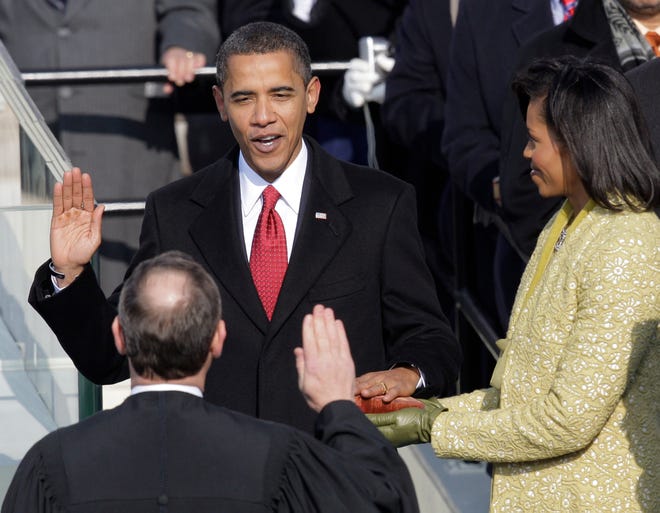 FILE - Barack Obama, left, joined by his wife Michelle, takes the oath of office from Chief Justice John Roberts to become the 44th president of the United States at the U.S. Capitol in Washington, D.C., in this Jan. 20, 2009 file photo. Obama is putting a symbolic twist on a time-honored tradition, taking the oath of office for his second term with his hand placed not on a single Bible, but two, one owned by Martin Luther King Jr. and one by Abraham Lincoln. (AP Photo/Jae C. Hong, File)