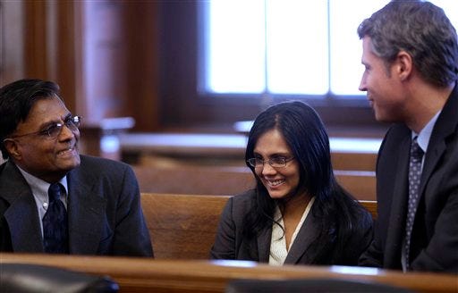 Annie Dookhan, center, a former Massachusetts chemist accused of faking test results at a state drug lab, speaks with her father Rasheed Khan, left, and her lawyer Nick Gordon, right, moments before her arraignment at Norfolk Superior Court, in Dedham, Mass., Wednesday, Jan. 9, 2013. Prosecutors allege Dookhan fabricated test results and tampered with drug evidence while testing substances in criminal cases.