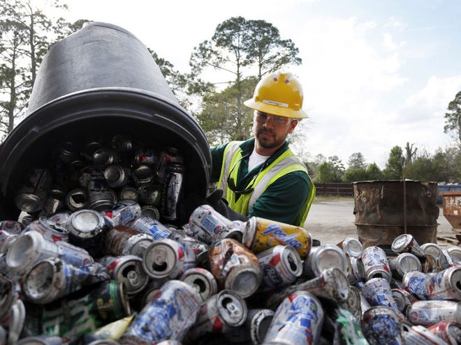 Operations supervisor Chris Barraza handles the aluminum cans at CMC Recycling in Gainesville, Fla., Thursday, January 10, 2013.