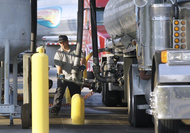 A man moves a fuel hose into position to begin loading gasoline into a tanker truck, June 29 at a North Little Rock, Ark., fuel distribution terminal.  AP Archives Photo