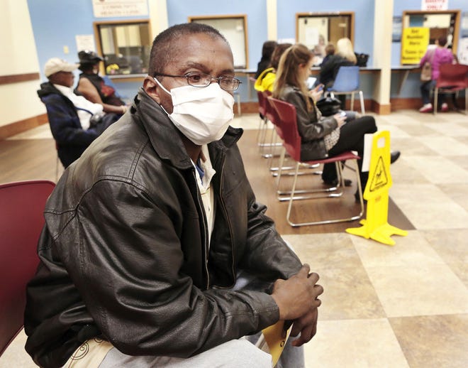 Walter Harris, of Oklahoma City, wears a protective mask while sitting with other clients in the waiting room Thursday at the Oklahoma City-County Health Department. Harris came for a flu shot and said he wore the mask to reduce the risk of catching germs while he was in the waiting area. PHOTO BY JIM BECKEL, THE OKLAHOMAN