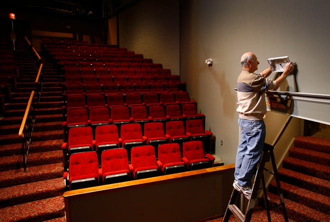 Building superintendent Bob Grazioso of Quincy changes an exit sign in the newly-renovate Company Theatre in Norwell on Jan. 9, 2013.