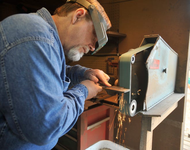 Spartanburg-based knife maker Ross Tyser makes a custom knife from a piece of Damascus steel he forged at his shop.