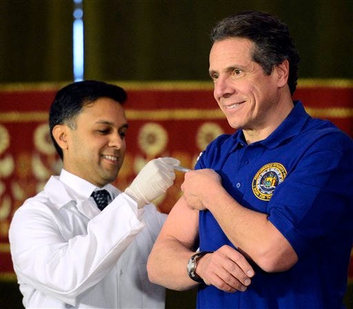 Gov. Andrew Cuomo Saturday declared a public health emergency because of the flu outbreak. On Thursday he got a flu shot from the state Health Commissioner Nirav Shah, left,  in the Red Room of the Capitol in Albany.