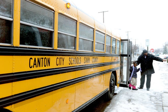 Tarik West helps student Kiera Conner off the bus at Imagine Schools located at 1500 Superior Avenue in Canton.