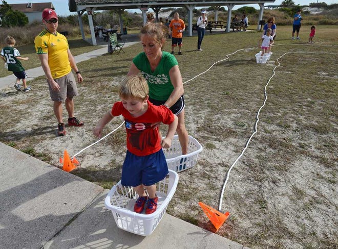 Penny Gorton and her son Shaine, 5, negotiate the final challenge of the Great Amazing Adventure Race, stepping into and moving laundry baskets. The 1-mile events are staged in NFL cities across the country with a goal of getting parents and their children to spend time together doing physical activities.   Bob.Mack@jacksonville.com