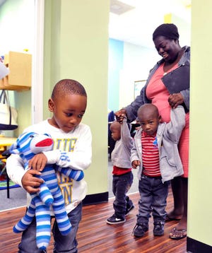 Ron Brown (left), 3, leads Rashad and Da'Mari Mobley to the playhouse when they arrive at the Early Learning Coalition with their mother, Elizabeth Mobley, last week at a new Pearl Street office in Jacksonville.
