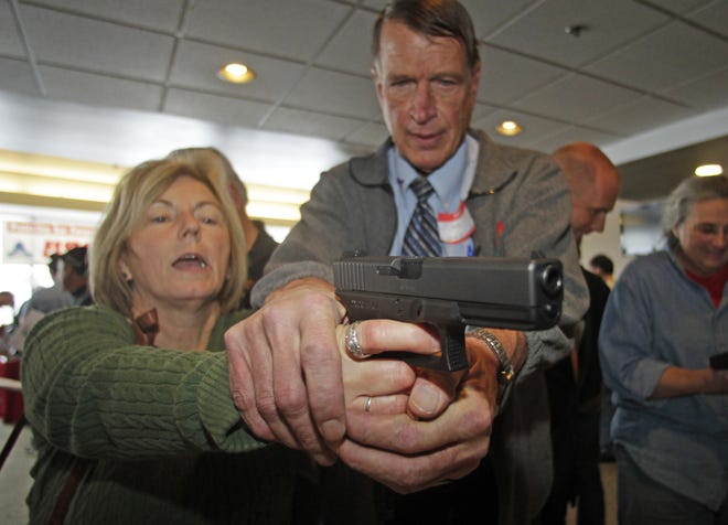 Christine Caldwell, left, receives firearms training with a 9mm Glock from personal defense instructor Jim McCarthy during concealed weapons training for 200 Utah teachers Thursday, Dec. 27, 2012, in West Valley City, Utah. The Utah Shooting Sports Council offered six hours of training in handling concealed weapons in the latest effort to arm teachers to confront school assailants. (AP Photo/Rick Bowmer)