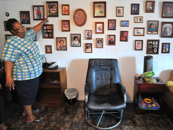 Annie Pearl Curtis, aunt of homicide victim Timothy Robinson, points at a baby photo of Robinson during a gathering at Robinson's mother's house in Archer on Monday. Police say Robinson was shot Sunday night.
