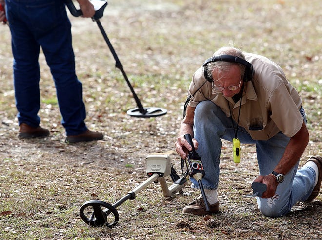 Jim Driskell digs a small hole to see what his metal detector sensed in Panama City on Monday.