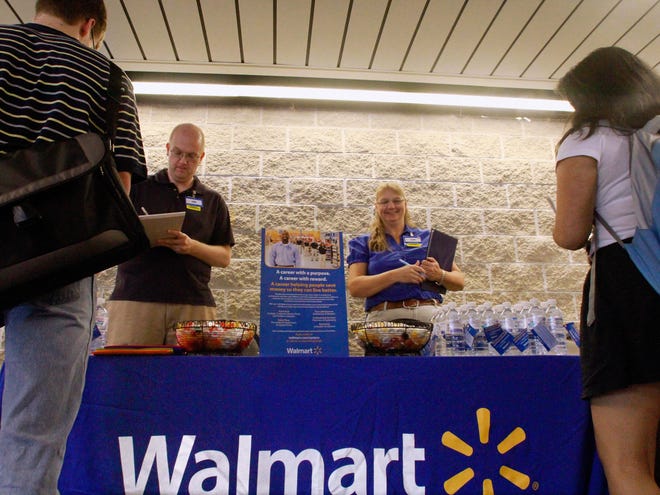 In this Thursday, Sept. 1, 2011, photo, Wal-Mart employees Jon Christians and Lori Harris take job applications and answers questions during a job fair at the University of Illinois Springfield campus in Springfield, Ill.  (AP Photo/Seth Perlman)