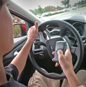 Hanover resident Julian Bartone, 17, attempts to text while driving a car during a safe-driving event Saturday in Hanover.