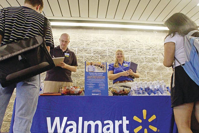 Seth Perlman/Associated Press Wal-Mart employees Jon Christians and Lori Harris take job applications and answer questions during a job fair at the University of Illinois Springfield campus in Springfield, Ill.