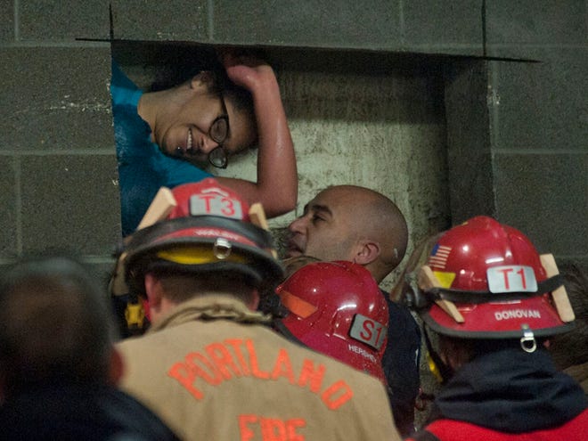 A woman is rescued from being trapped inside a wall of the parking garage Wednesday at the Gretchen Kafoury Commons in SW Portland, Ore. Portland firefighters worked for over three and a half hours cutting her free.