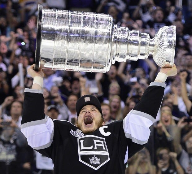 Los Angeles Kings captain Dustin Brown hoists the Stanley Cup after the Kings beat the New Jersey Devils 6-1 in Game 6 of last year's Stanley Cup final.