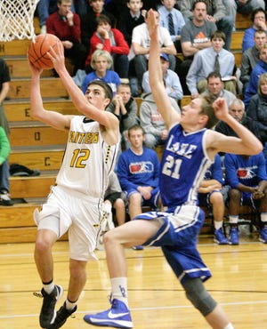 Perry's Brock Weston gets in a shot with Lake's Alex Belinsky moving in fast for a block.